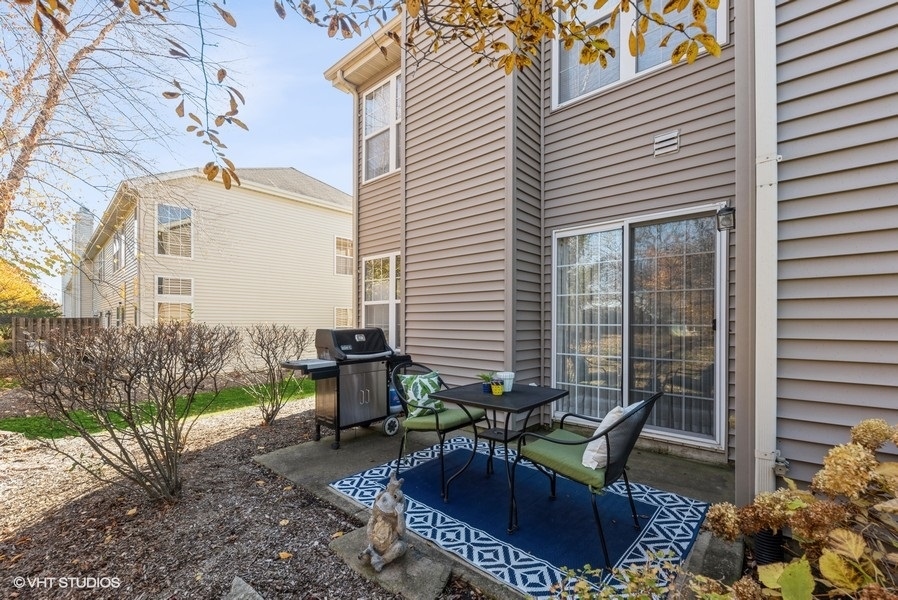 560 Lancaster Drive Pingree Grove, IL 60140 - Photo 18 of 26 a view of a patio with couple of chairs and potted plants