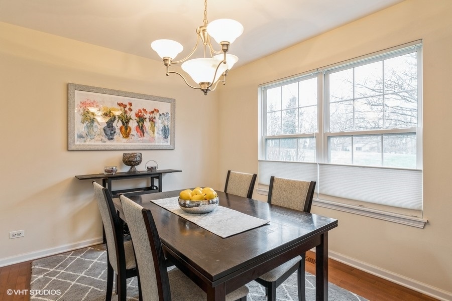 560 Lancaster Drive Pingree Grove, IL 60140 - Photo 6 of 26 a view of a dining room with furniture a chandelier and wooden floor