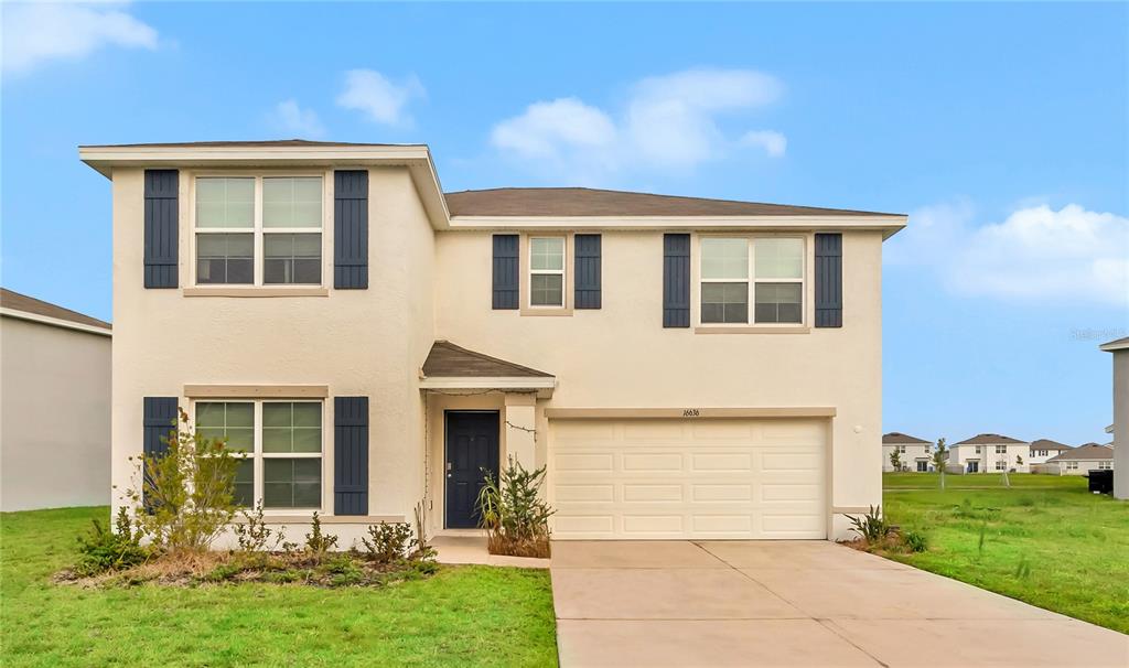 a front view of a house with a yard and garage