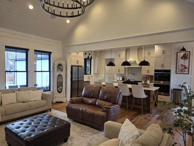 a view of a hallway with wooden floor and a living room