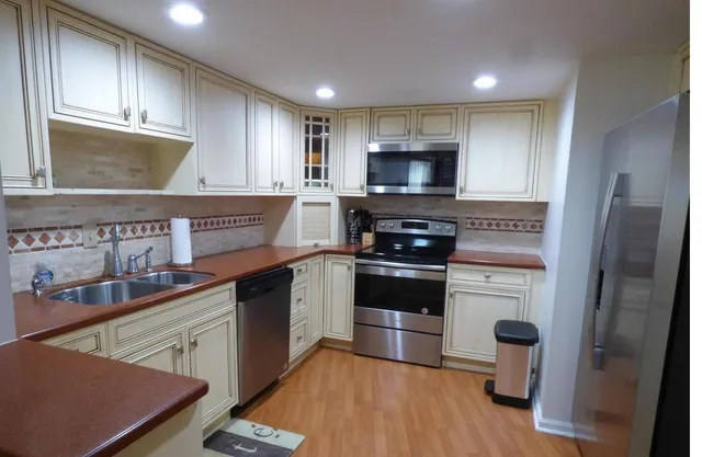 a kitchen with stainless steel appliances a stove refrigerator sink and cabinets
