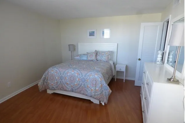 a bedroom with a bed and a wooden floor