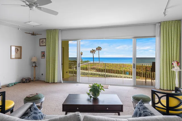 a living room with furniture and a floor to ceiling window