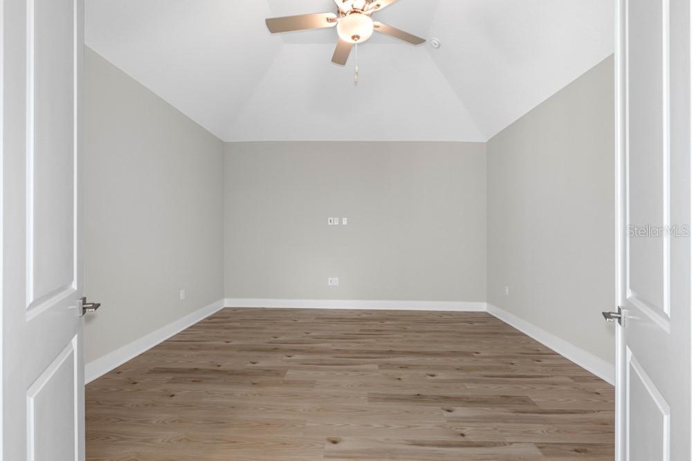 13510 Haflinger Way Hudson, FL 34667 - Photo 9 of 13 wooden floor in an empty room with a window