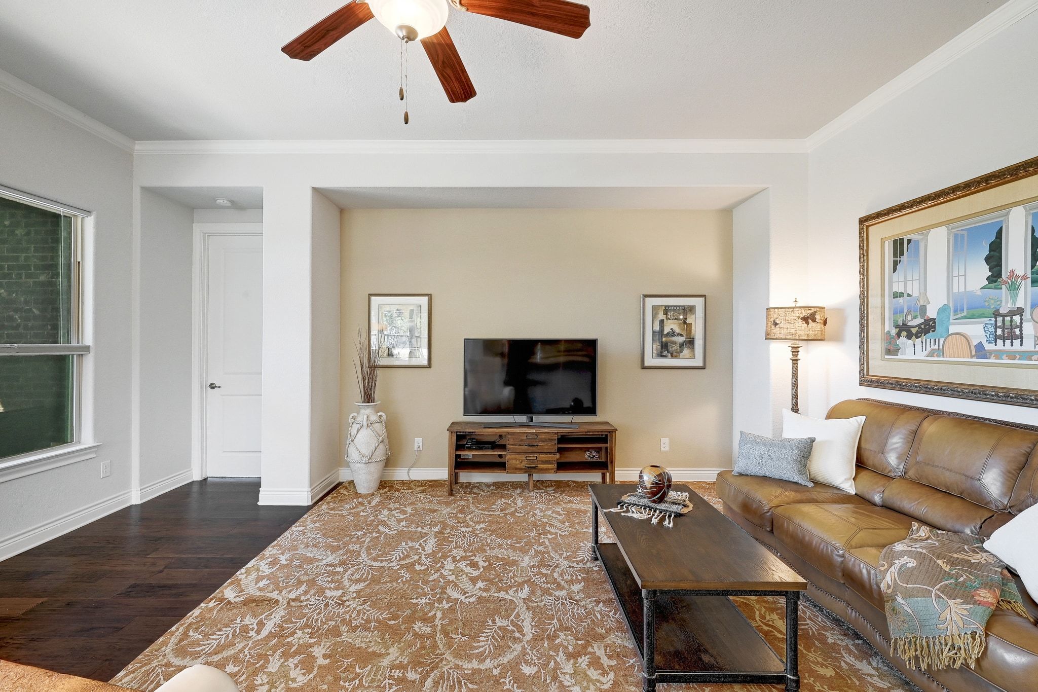 960 Blue Ridge Drive Dripping Springs, TX 78620 - Photo 4 of 38 Living area featuring a ceiling fan, crown molding, and dark wood-style flooring
