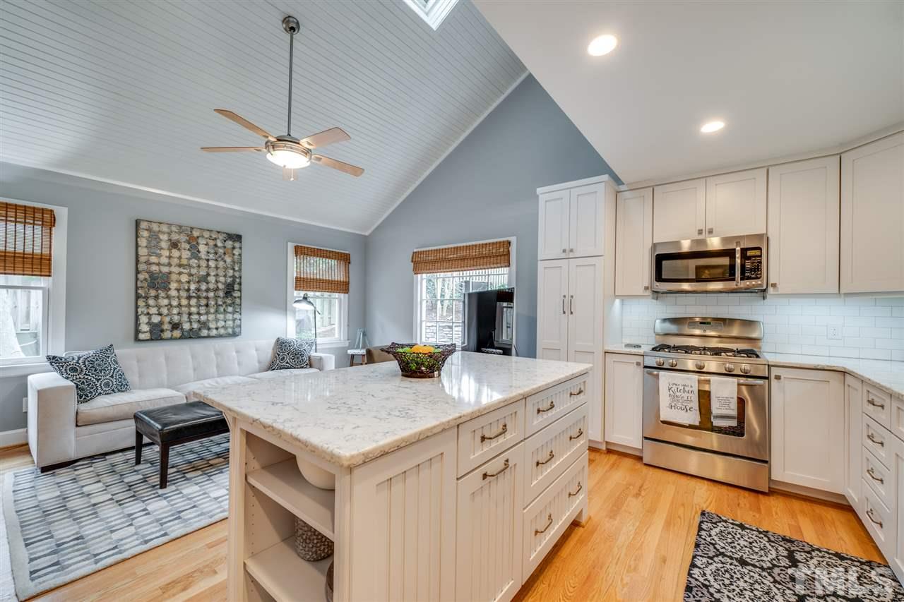 2607 Van Dyke Avenue Raleigh, NC 27607 - Photo 5 of 26 a kitchen with stainless steel appliances granite countertop a stove top oven a sink dishwasher a dining table and chairs with wooden floor