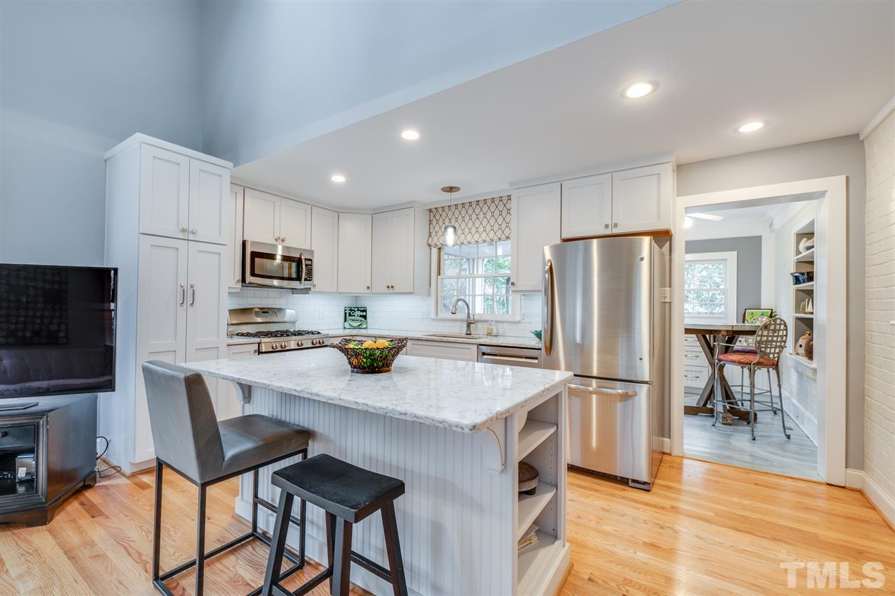 2607 Van Dyke Avenue Raleigh, NC 27607 - Photo 8 of 26 a kitchen with stainless steel appliances a refrigerator a stove a sink a dining table and chairs