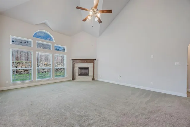 an empty room with windows and fireplace