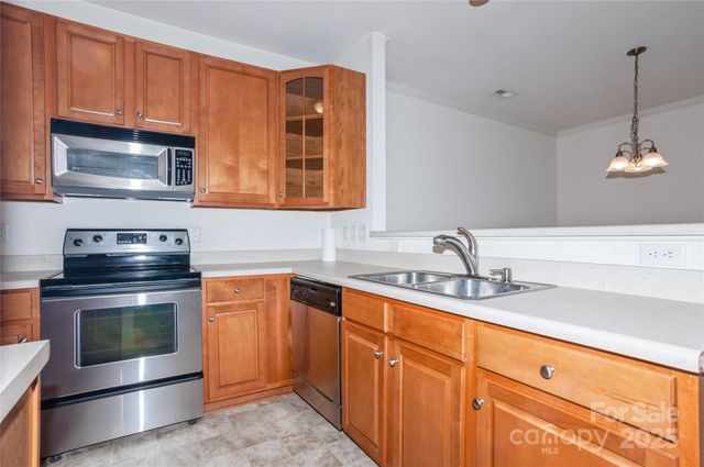 a kitchen with stainless steel appliances granite countertop a sink stove and microwave