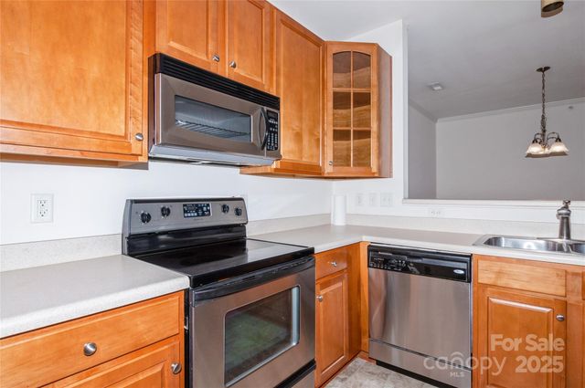 a kitchen with stainless steel appliances granite countertop a stove microwave and sink