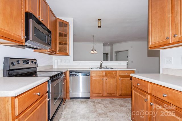 a kitchen with stainless steel appliances granite countertop a sink stove and cabinets