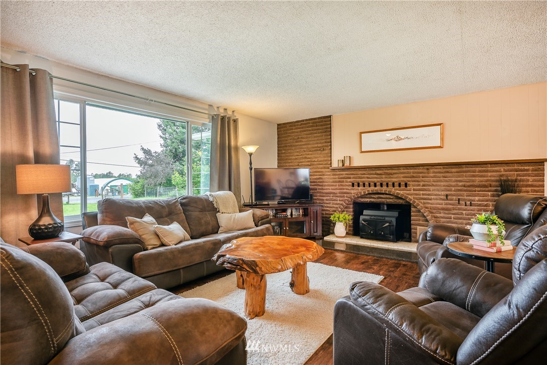 6820 Goodwin Road Everson, WA 98247 - Photo 4 of 34 a living room with furniture a large window and a fireplace