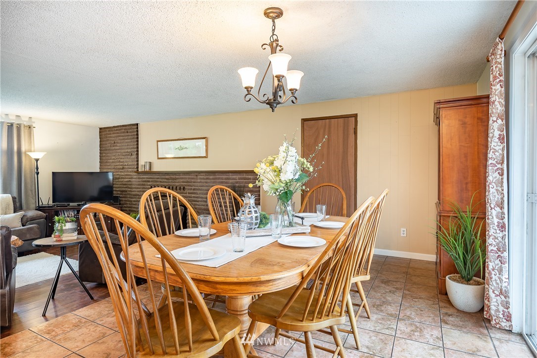 6820 Goodwin Road Everson, WA 98247 - Photo 6 of 34 a view of a dining room with furniture a chandelier and large windows