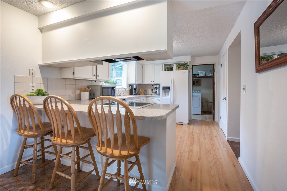 6820 Goodwin Road Everson, WA 98247 - Photo 9 of 34 a kitchen with stainless steel appliances a table chairs refrigerator and a sink