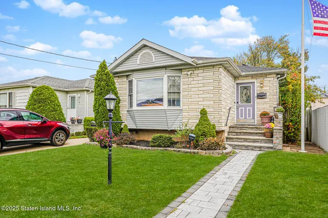 a front view of a house with a garden and plants