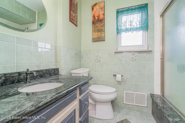 a bathroom with a granite countertop sink toilet and a shower