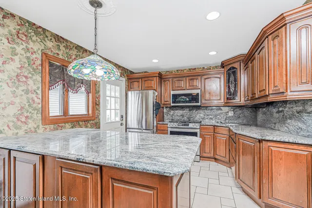 a kitchen with stainless steel appliances granite countertop a sink a stove cabinets and a kitchen island