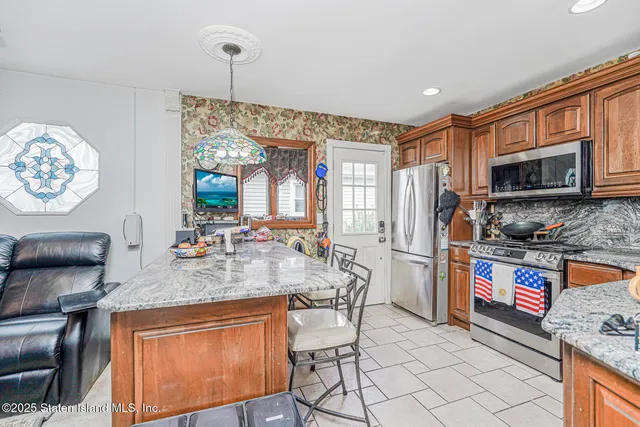 a kitchen with stainless steel appliances granite countertop a stove top oven a sink and a microwave