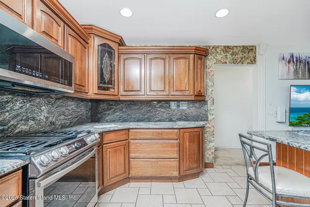 a kitchen with stainless steel appliances granite countertop a stove top oven microwave and cabinets