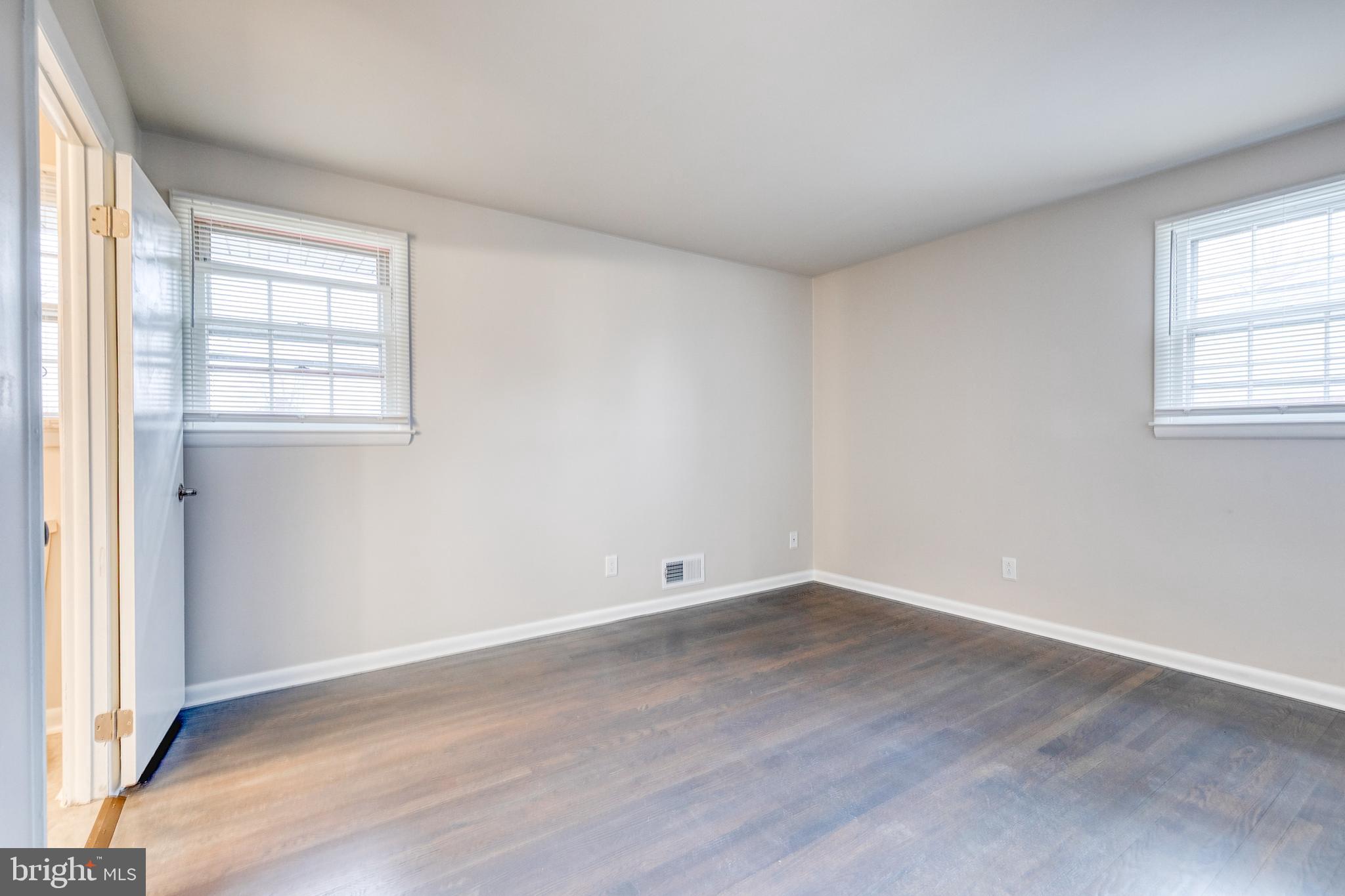 3719 Brenbrook Drive Randallstown, MD 21133 - Photo 11 of 24 an empty room with wooden floor and windows