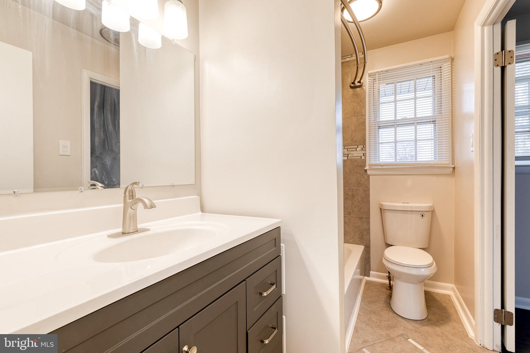 3719 Brenbrook Drive Randallstown, MD 21133 - Photo 14 of 24 a bathroom with a sink a toilet and a mirror