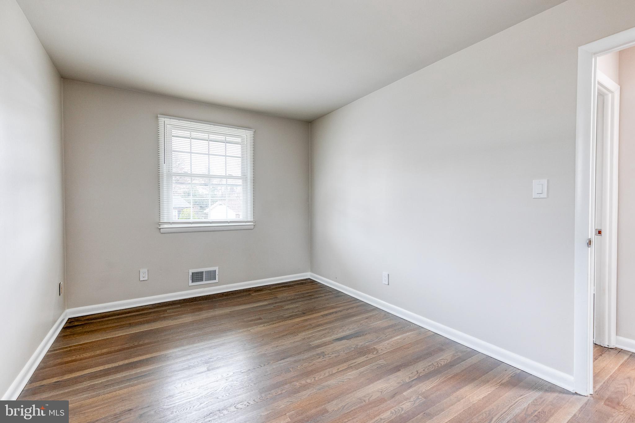 3719 Brenbrook Drive Randallstown, MD 21133 - Photo 16 of 24 an empty room with wooden floor and windows