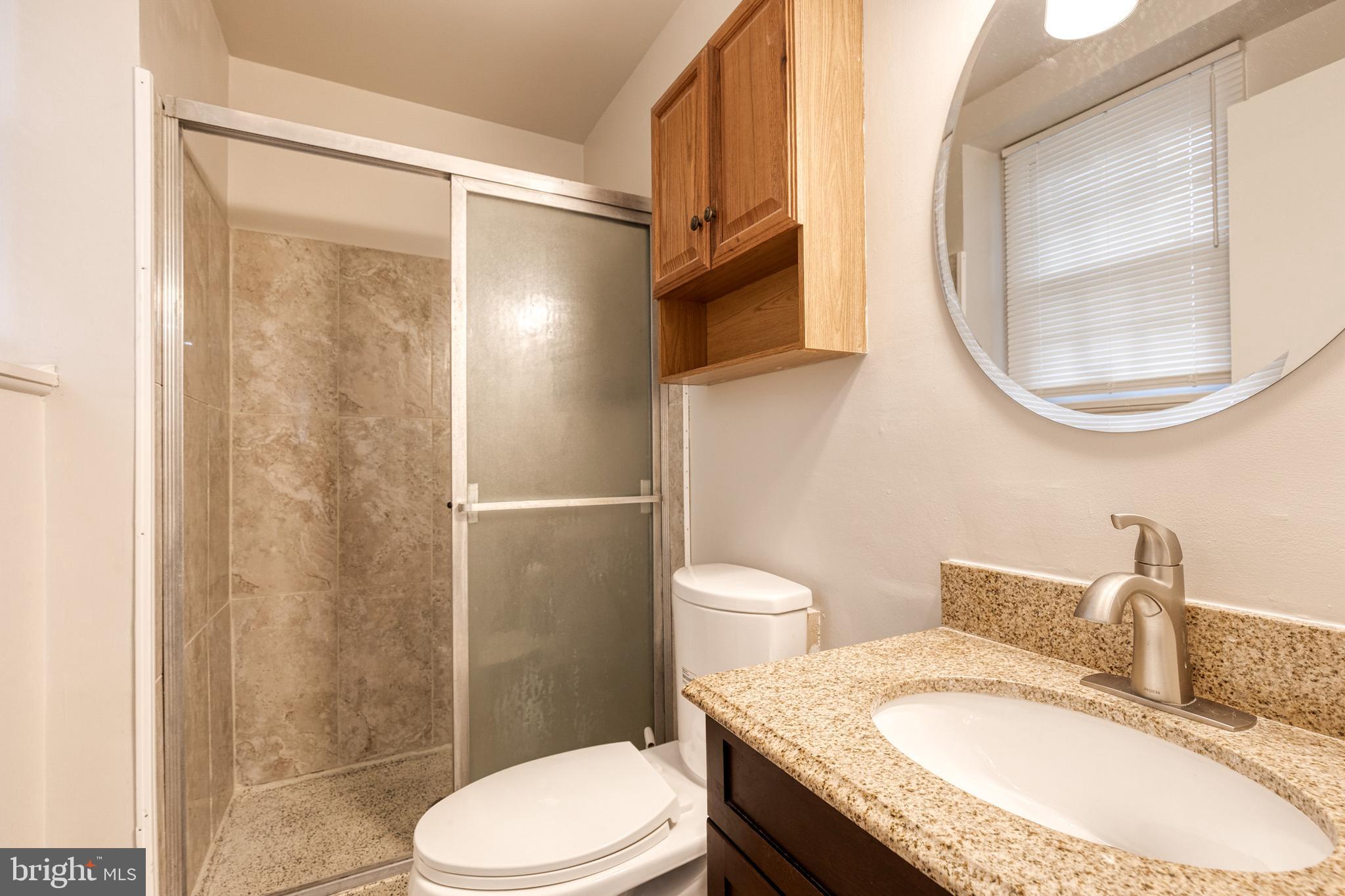 3719 Brenbrook Drive Randallstown, MD 21133 - Photo 20 of 24 a bathroom with a granite countertop toilet sink and mirror