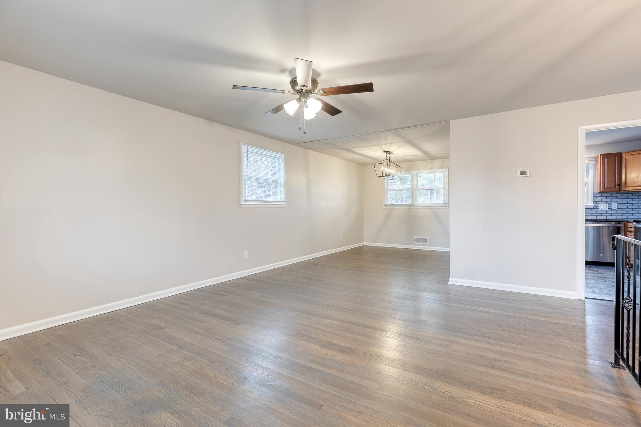 3719 Brenbrook Drive Randallstown, MD 21133 - Photo 3 of 24 an empty room with wooden floor ceiling fan and windows