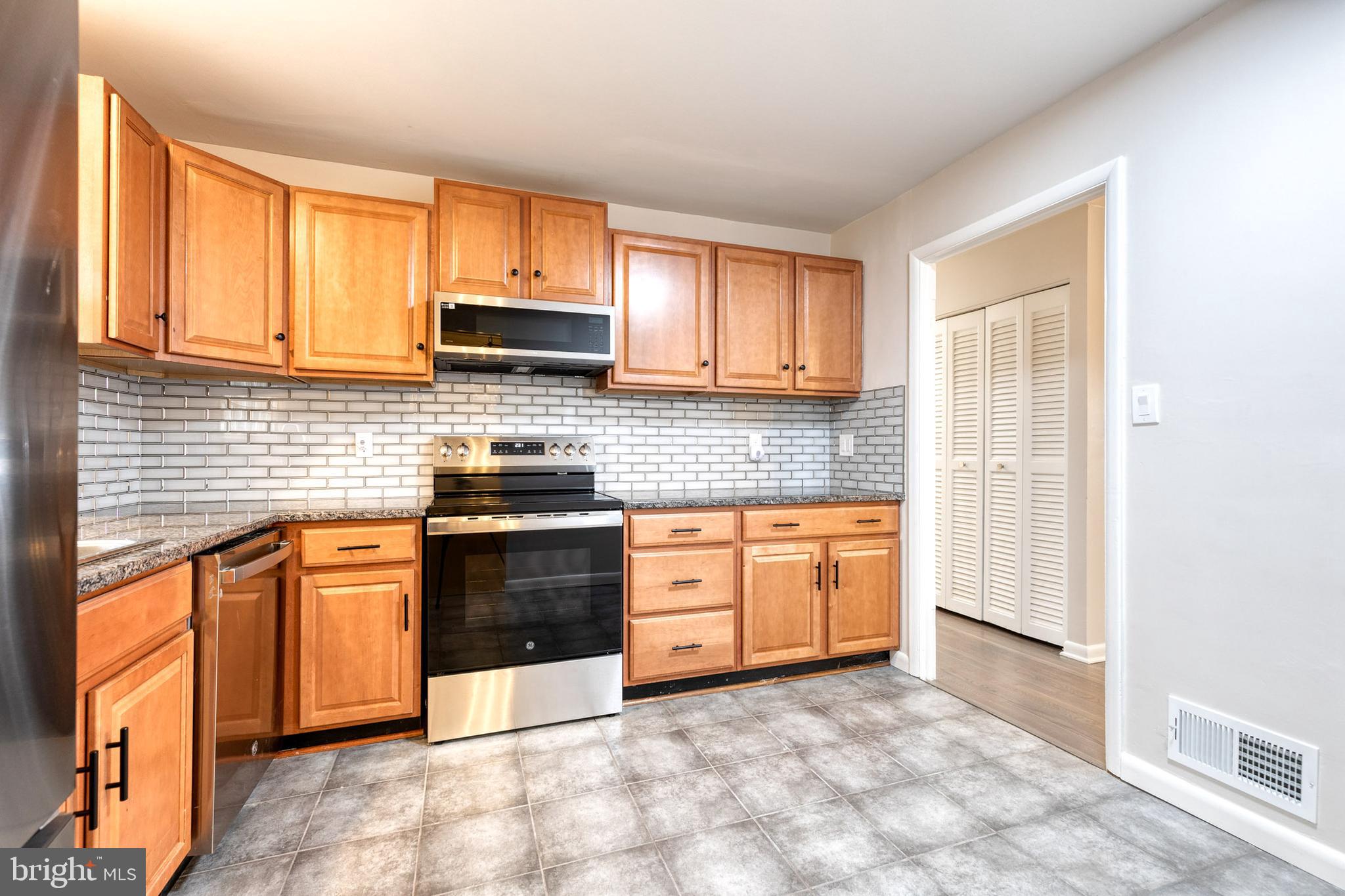 3719 Brenbrook Drive Randallstown, MD 21133 - Photo 8 of 24 a kitchen with stainless steel appliances granite countertop a stove a sink and a microwave
