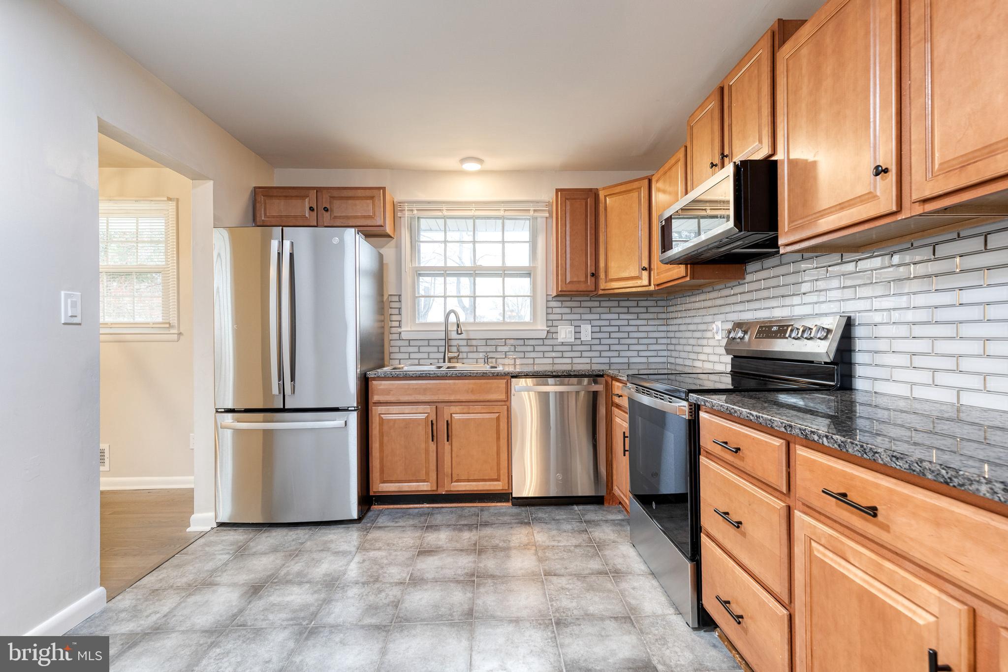 3719 Brenbrook Drive Randallstown, MD 21133 - Photo 9 of 24 a kitchen with stainless steel appliances granite countertop a refrigerator sink and stove