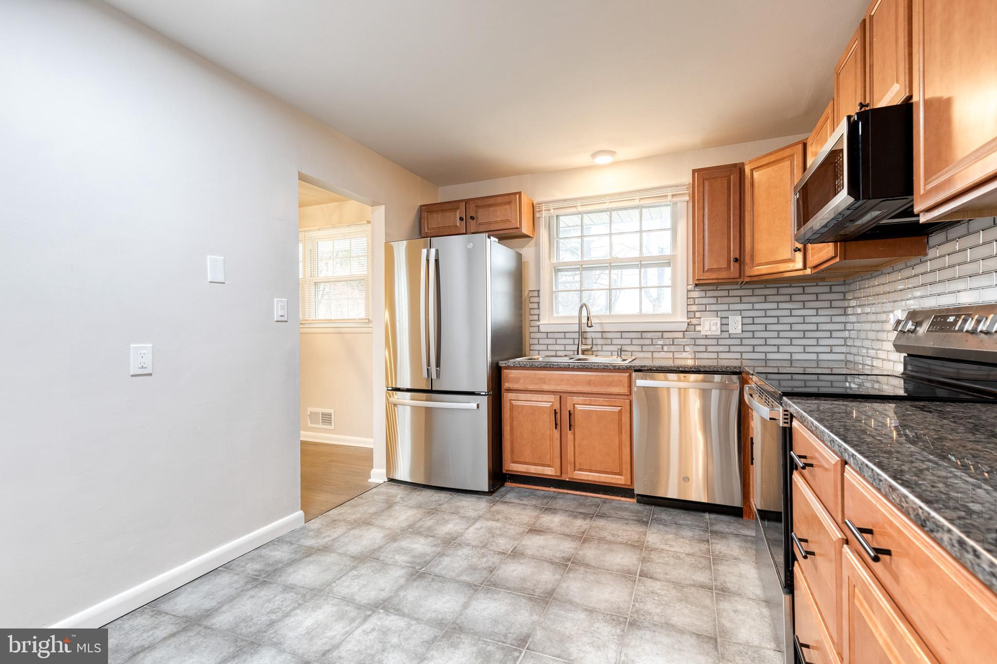 3719 Brenbrook Drive Randallstown, MD 21133 - Photo 10 of 24 a kitchen with stainless steel appliances granite countertop a refrigerator a sink a stove a microwave a counter space and cabinets