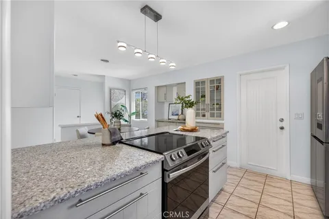 a kitchen with granite countertop a sink and white cabinets