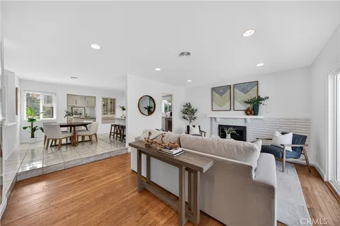 a living room with fireplace furniture and a wooden floor