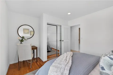 a bedroom with a bed a mirror and chair