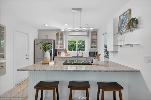 a kitchen with stainless steel appliances granite countertop a kitchen island a stove a table and chairs in it