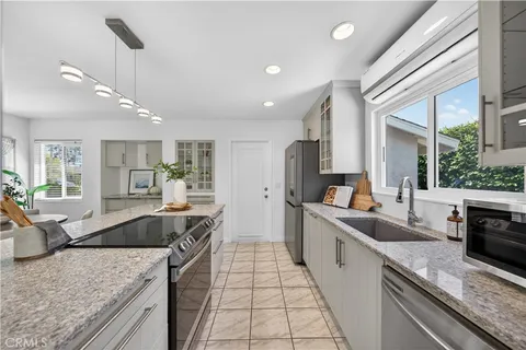 a large kitchen with granite countertop a large counter top stainless steel appliances and a counter space