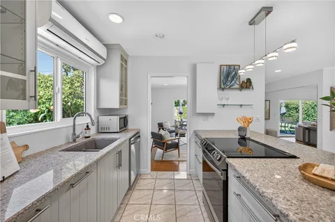 a kitchen with granite countertop a sink stove and cabinets