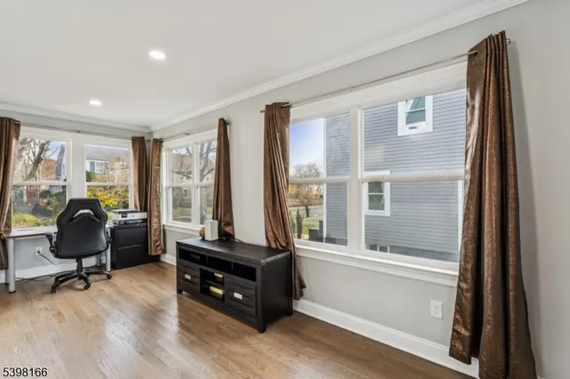 a living room with furniture floor to ceiling window and a wooden floor