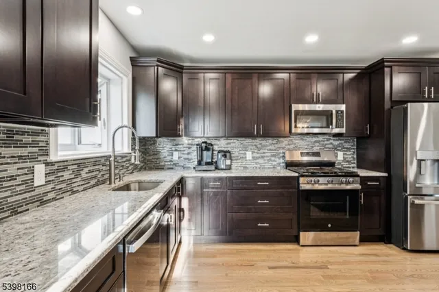 a kitchen with granite countertop stainless steel appliances and wooden cabinets