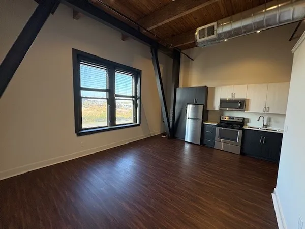 a kitchen with stainless steel appliances wooden floors and refrigerator