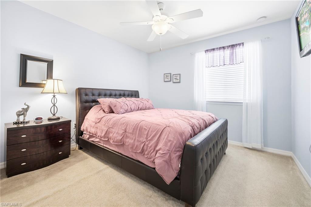 3916 Cherrybrook Loop Fort Myers, FL 33966 - Photo 16 of 31 Carpeted bedroom with light blue walls, featuring a window with white blinds and sheer curtains