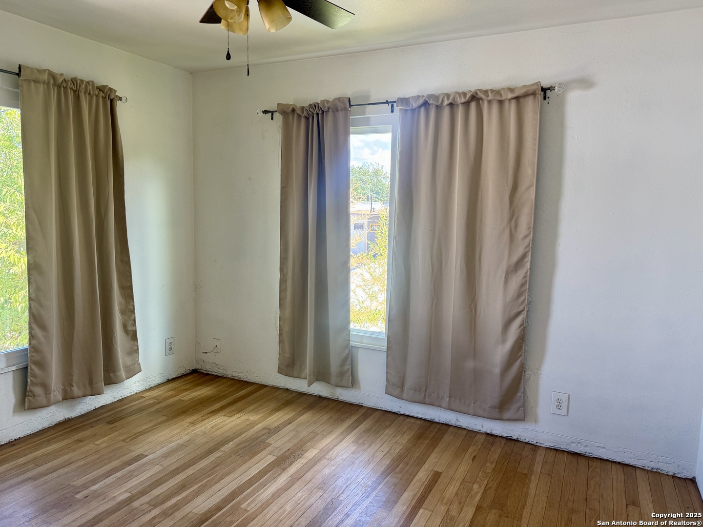 108 Robert E Lee, Unit 2 San Antonio, TX 78214 - Photo 5 of 8 an empty room with wooden floor and windows