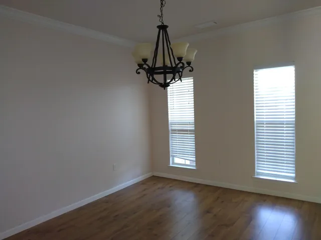 a view of a room with wooden floor air conditioner and windows