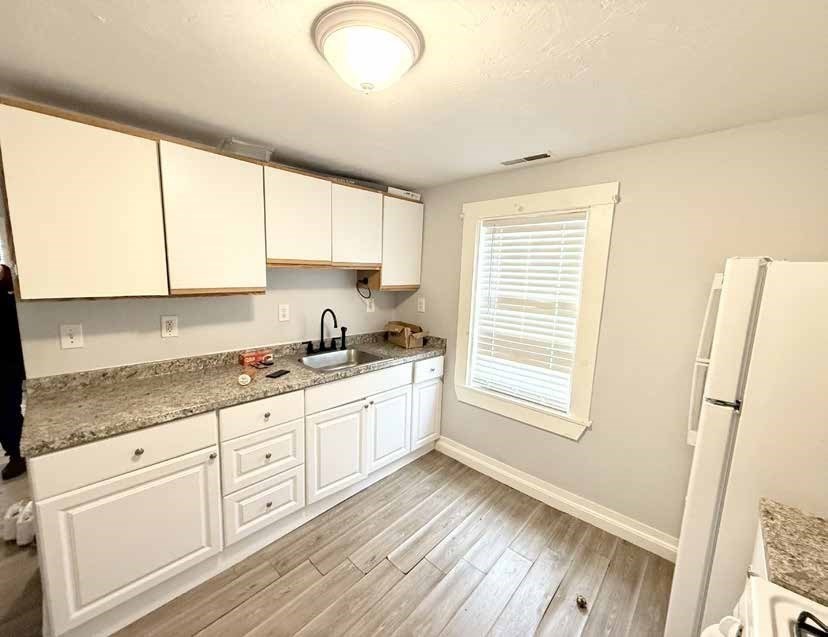 8 Cherry Street Lowell, MA 01852 - Photo 7 of 17 a kitchen with granite countertop white cabinets and white appliances