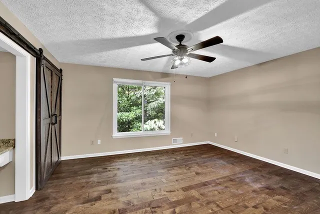 an empty room with a window and a ceiling fan