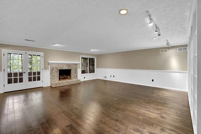 an empty room with wooden floor and fireplace