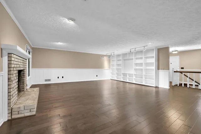 a view of a kitchen with wooden floor and brick walls