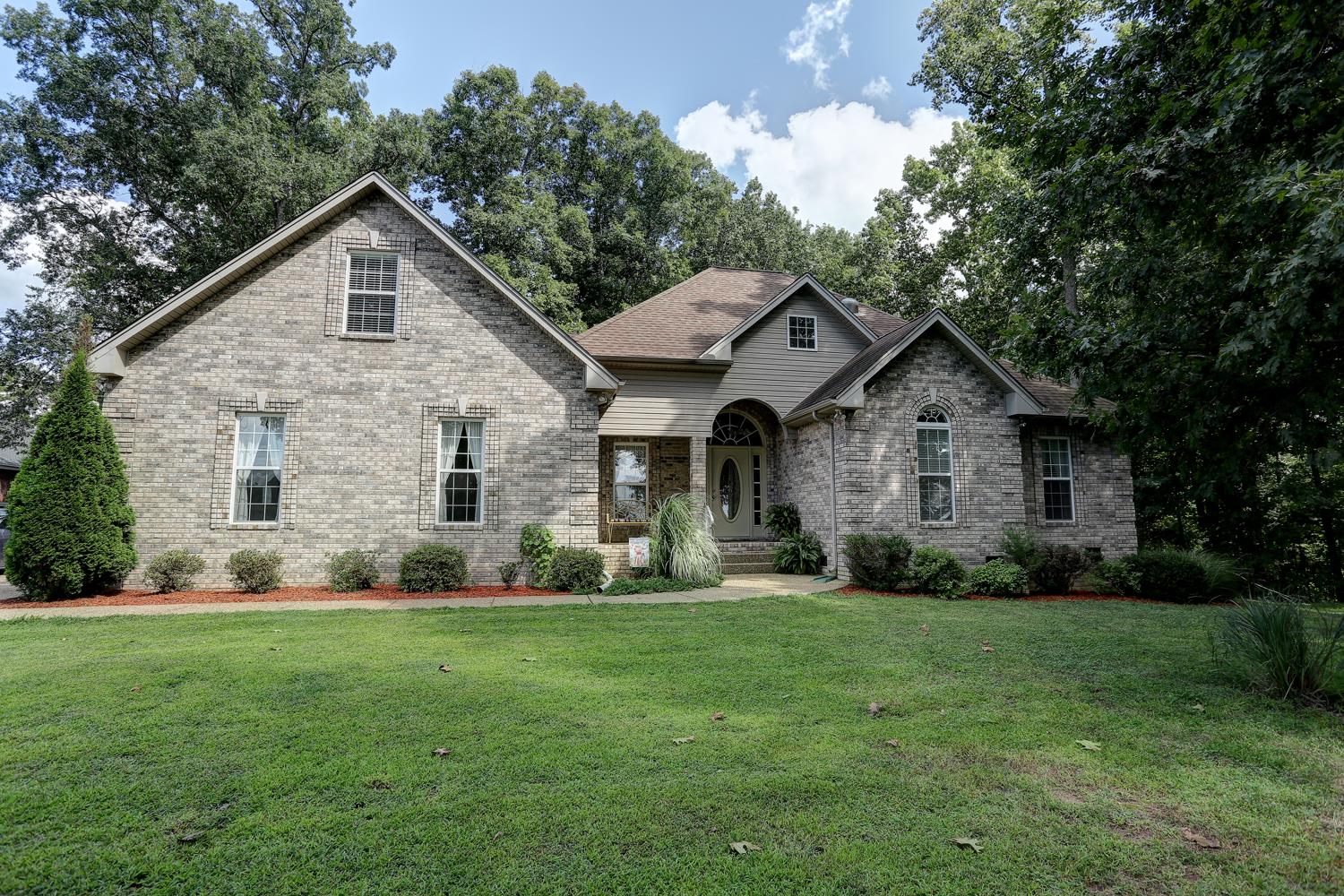a front view of house with yard and green space