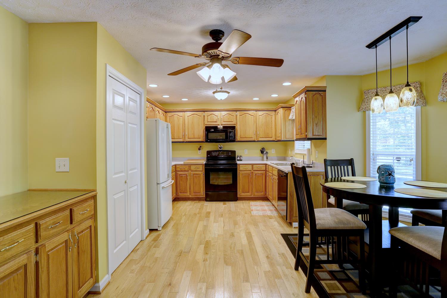 105 Lear Road Portland, TN 37148 - Photo 7 of 25 a kitchen with stainless steel appliances granite countertop a refrigerator a sink dishwasher a stove and a dining table with wooden floor