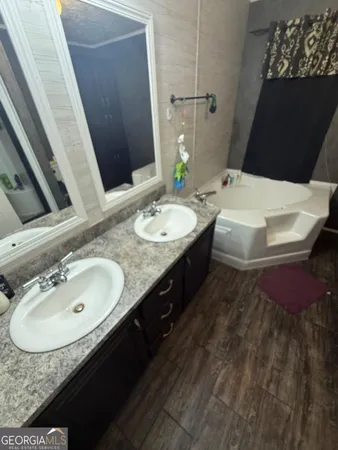 a bathroom with a tub sink and mirror